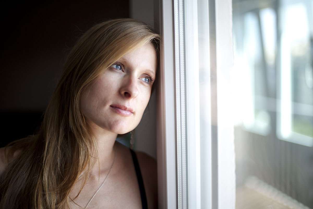 woman gazing out window wondering What To Expect During Opiate Detox