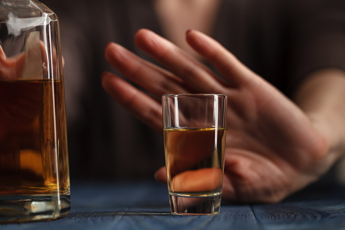 hand pushing away a shot of whiskey thinking can i quit drinking alcohol cold turkey