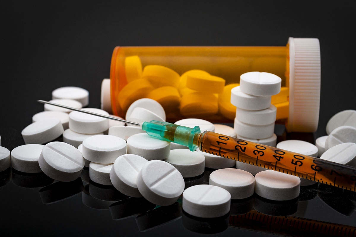 pills and syringe representing opiate abuse statistics