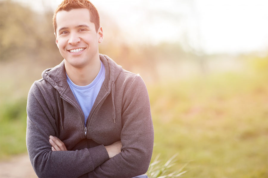 Young adult male smiling concept image for a successful addiction recovery